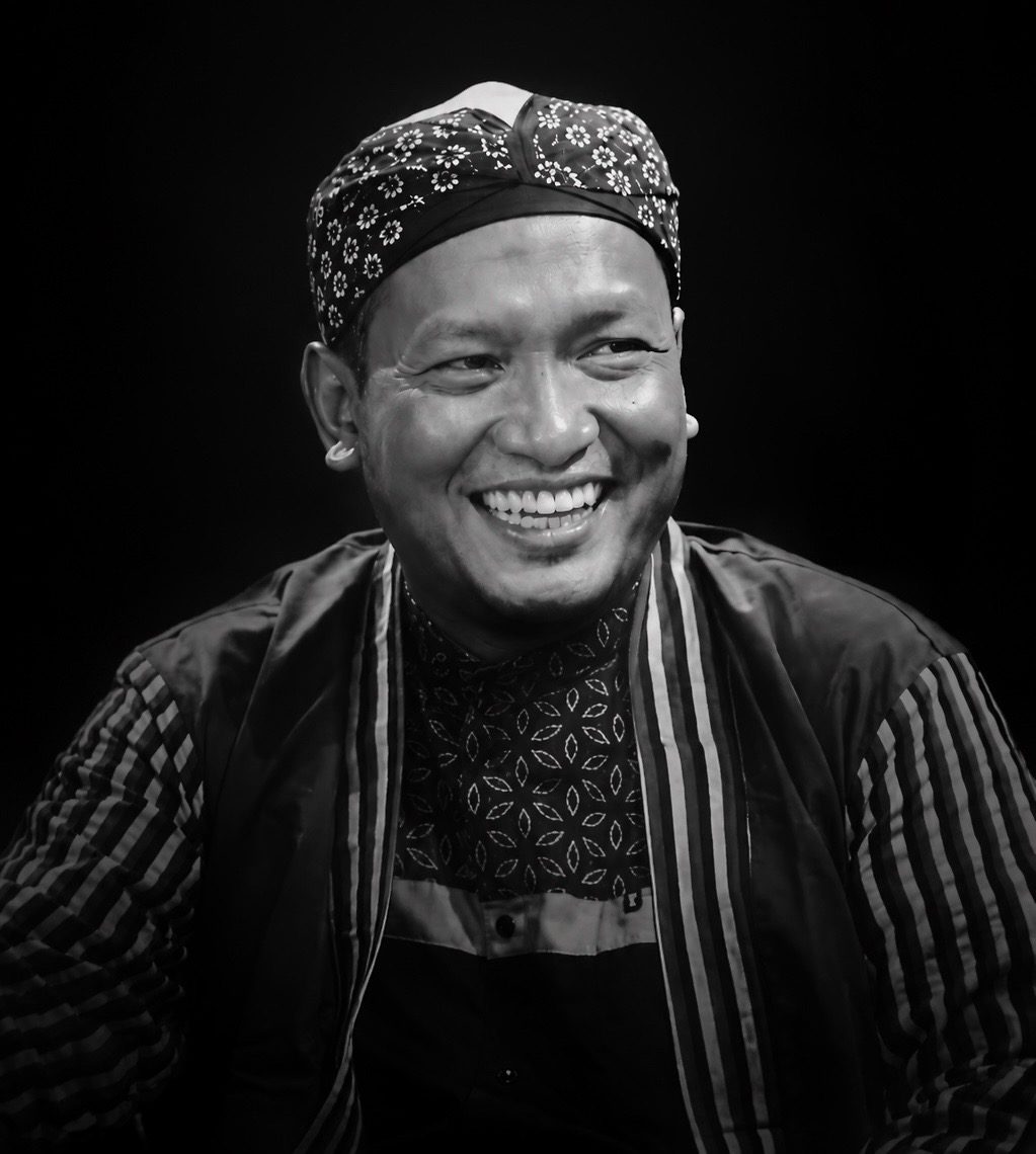 Potret Salim A. Fillah mengenakan iket kepala batik, tersenyum